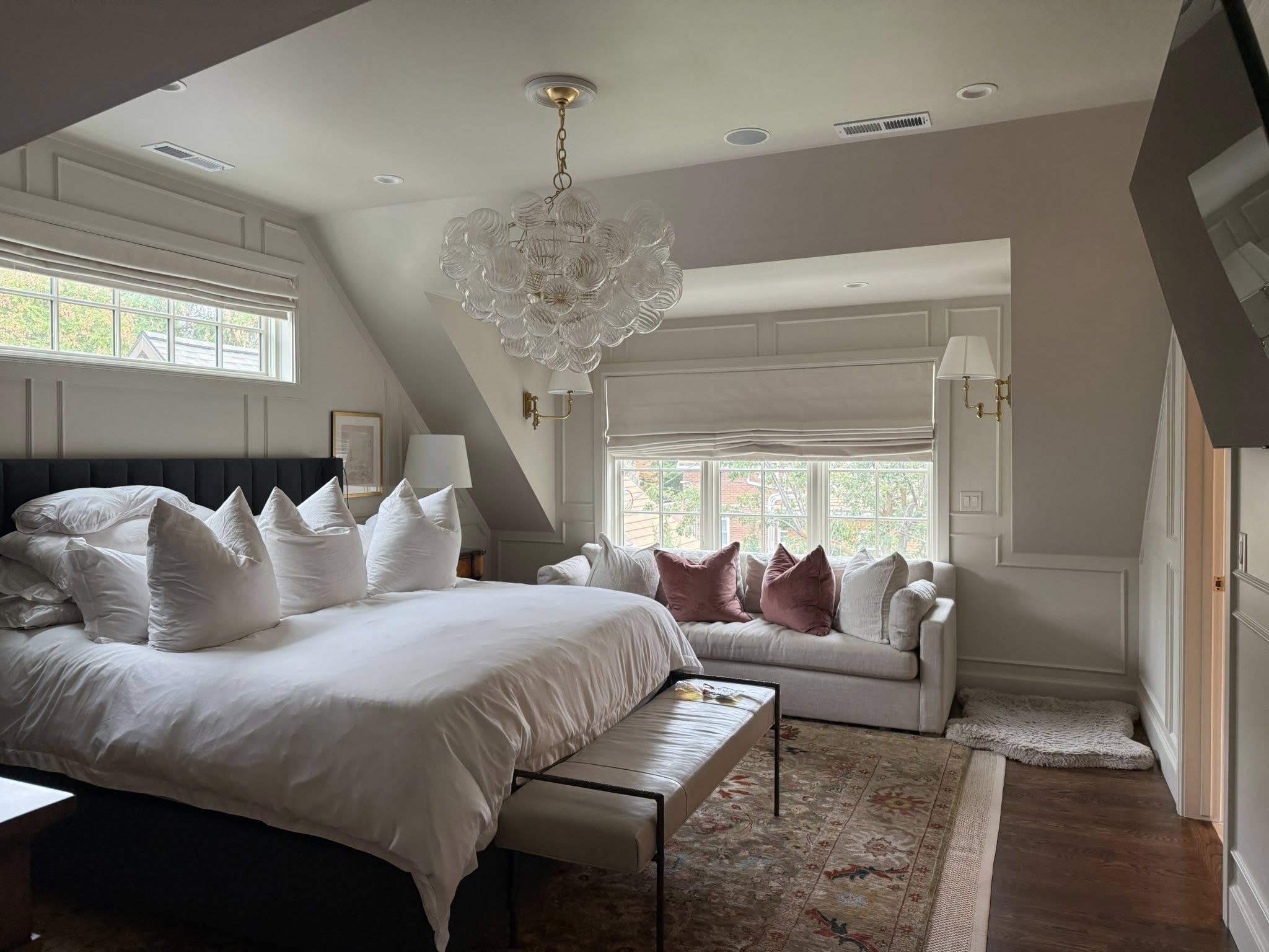 Elegant master bedroom with fresh linens and chandelier after full clean