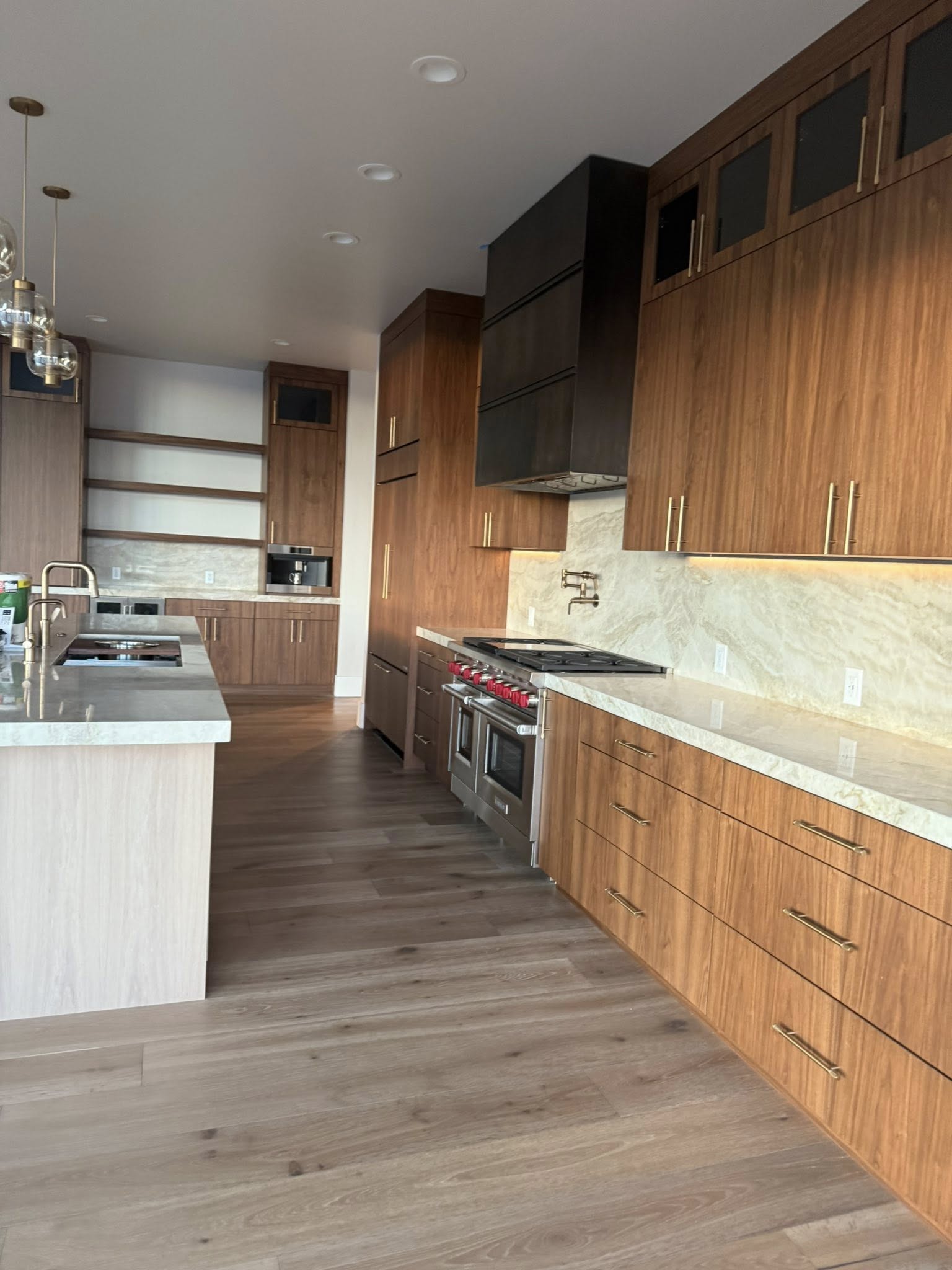 Modern walnut kitchen with marble backsplash and stainless appliances after deep clean
