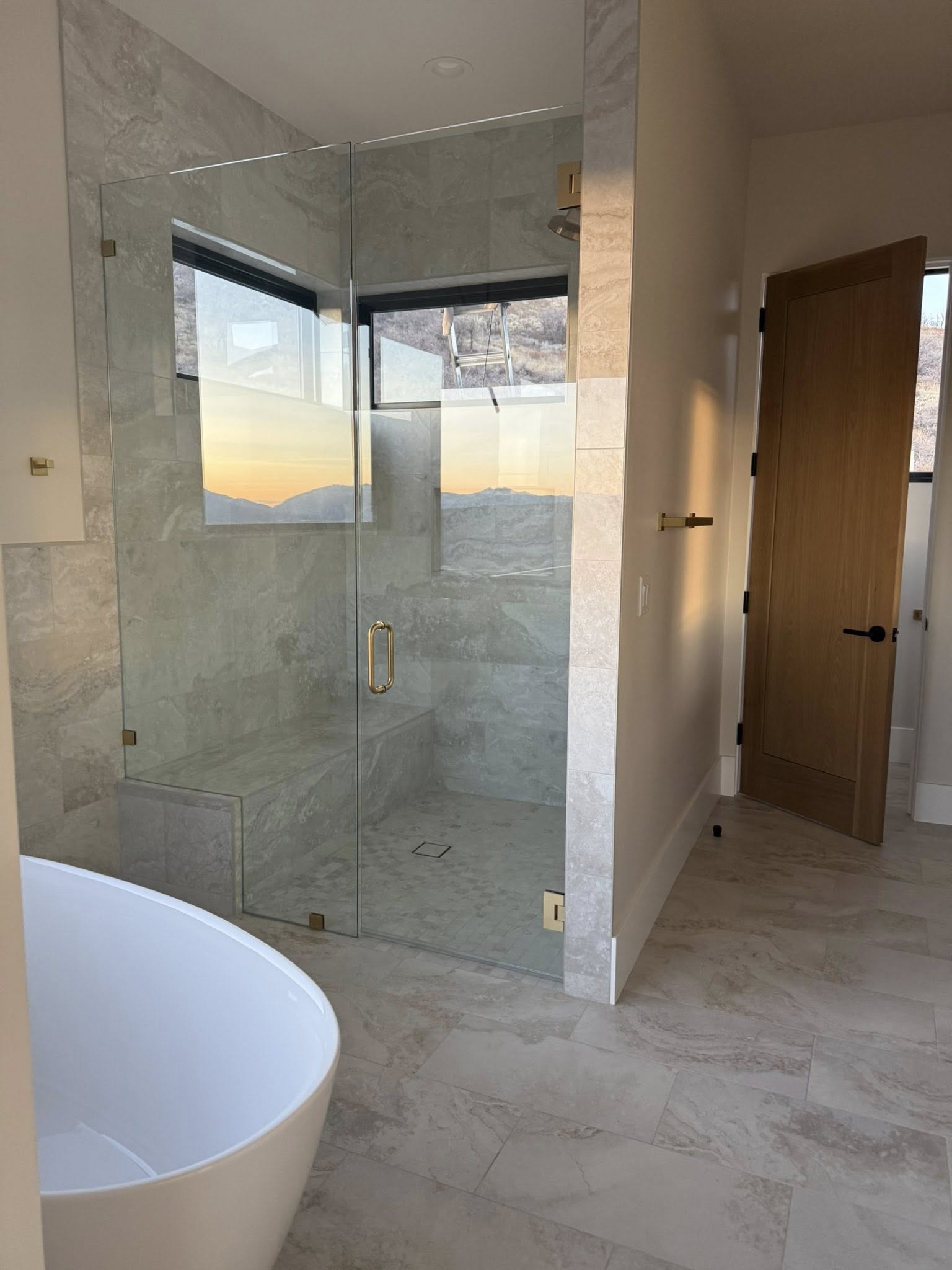Marble tile bathroom with glass shower and freestanding tub after full sanitizing